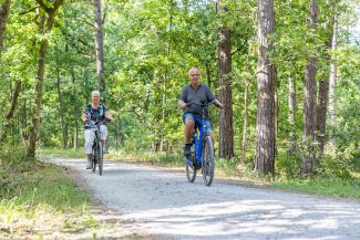 Twee mensen fietsen door het bos bij West-Terschelling